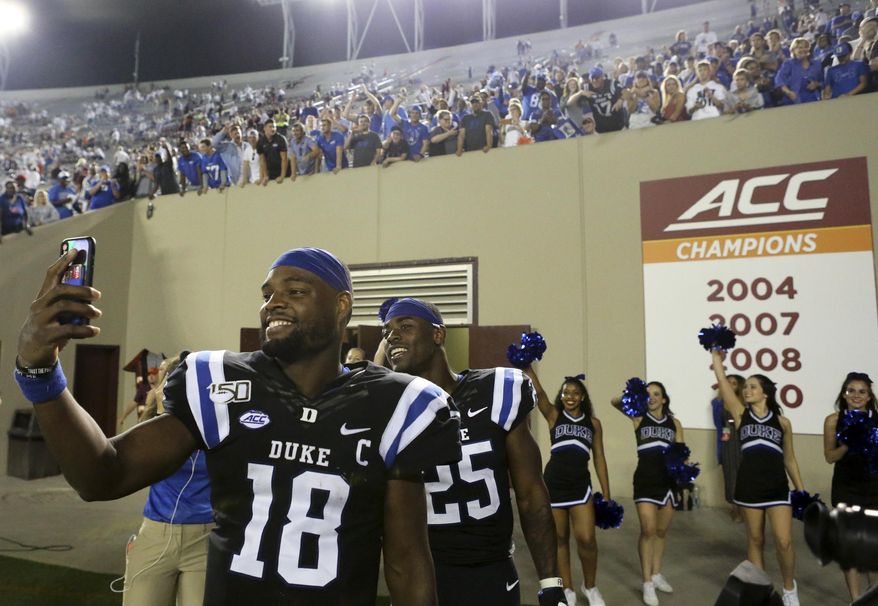Duke quarterback Quentin Harris (18) and running back Deon Jackson (25) celebrate at the conclusion of an NCAA college football game against Virginia Tech, Friday, Sept. 27, 2019, in Blacksburg, Va. Duke won 45-10. (Matt Gentry/The Roanoke Times via AP)