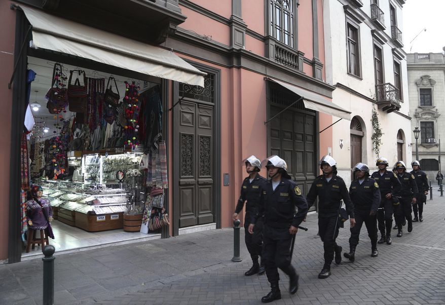 Police patrol past a souvenir shop located between the presidential palace and Congress in Lima, Peru, Wednesday, Oct. 1, 2019. Peru is in the throes of its deepest constitutional crisis in nearly three decades as President Martín Vizcarra and the opposition-controlled congress engage in an acrimonious tug of war over who should lead the South American nation. (AP Photo/Martin Mejia)
