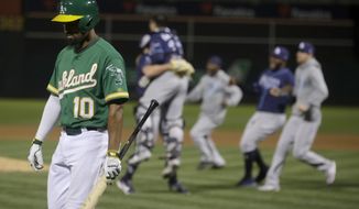 Oakland Athletics&#39; Marcus Semien (10) walks off the field as Tampa Bay Rays players celebrate after defeating the Athletics in an American League wild-card baseball game in Oakland, Calif., Wednesday, Oct. 2, 2019. (AP Photo/Jeff Chiu)