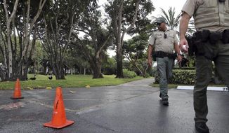 Law enforcement officers walk along a path where a couple claim a bobcat attacked them Friday, Oct. 4, 2019, in Fort Lauderdale, Fla. The woman was hospitalized with serious wounds and her husband was also treated for injuries. Florida wildlife officials say attacks by bobcats on humans are rare and wildlife experts say it usually happens when the animal is rabid or otherwise sick. (Amy Beth Bennett/South Florida Sun-Sentinel via AP)