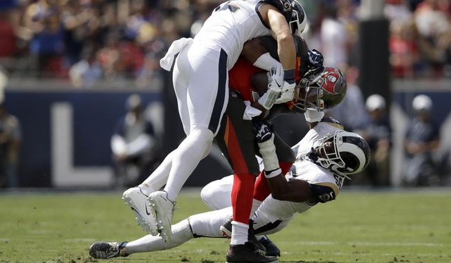 Los Angeles Rams outside linebacker Clay Matthews, top, and defensive end Dante Fowler sack Tampa Bay Buccaneers quarterback Jameis Winston during the first of an NFL football game Sunday, Sept. 29, 2019, in Los Angeles. (AP Photo/Marcio Jose Sanchez)