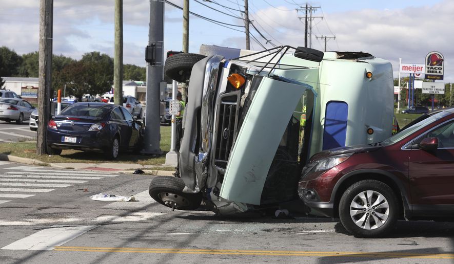 Sylvania Township fire and police crews respond to a multiple vehicle crash involving a bus, Friday, Oct. 4, 2019, in Sylvania Township, near Toledo, Ohio. Authorities say the bus carrying developmentally disabled people flipped over during the crash and sent 13 people to hospitals. (Lori King/The Blade via AP)
