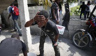 A demonstrator washes his faces from the effects of tear gas during a protest demanding the resignation of President Jovenel Moise, in Port-au-Prince, Haiti, Friday, Oct. 4, 2019. After a two-day respite from the recent protests that have wracked Haiti&#39;s capital, opposition leaders urged citizens angry over corruption, gas shortages, and inflation to join them for a massive protest march to the local headquarters of the United Nations. (AP Photo/Rebecca Blackwell)