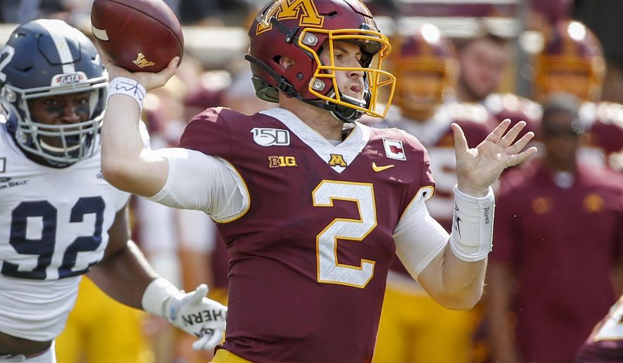 FILE - In this Sept. 14, 2019, file photo, Minnesota quarterback Tanner Morgan (2) throws for a touchdown as Georgia Southern defensive end Raymond Johnson III (92) approaches during the first quarter of an NCAA college football game in Minneapolis. Morgan has zoomed to the top of the Big Ten leaders in passing, helping Minnesota start unbeaten after four games. Now the Gophers have an ugly loss to Illinois from last year to avenge. (AP Photo/Bruce Kluckhohn, File)