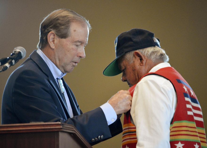 U.S. Sen. Tom Udall, D-New Mexico, left, pins replacement medals to All Pueblo Council of Governors Chairman Edward Paul Torres during a special ceremony at Isleta Pueblo, N.M., Friday, Oct. 4, 2019. Sen. Udall presented the medals to Torres and former Isleta Tribal councilman Diego Lujan, not seen, both veterans of the Vietnam War, after he found out the men were never presented with their earned military medals. (AP Photo/Russell Contreras)