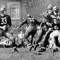 In this Sept. 13, 1942, file photo, Washington Redskins quarterback Sammy Baugh, left, drops back to pass against the Chicago Bears during a football game in Washington. “Slingin’” Sammy Baugh, Washington’s top draft choice in 1937, gets credit for being the NFL’s first big-yardage passer. (AP Photo/File)  **FILE**