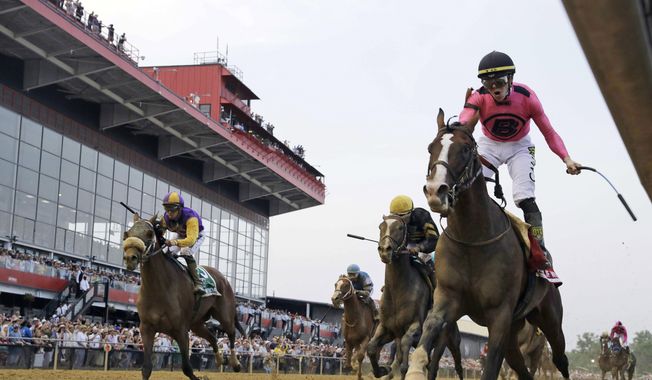 FILE - In this May 18, 2019, file photo, jockey Tyler Gaffalione, right, reacts aboard War of Will, as they crosses the finish line first to win the Preakness Stakes horse race at Pimlico Race Course in Baltimore. The owners of the historic racetrack that hosts the Preakness Stakes and Baltimore officials have reached an agreement to keep the Triple Crown series&#x27; middle jewel in the city. (AP Photo/Steve Helber, File) ***FILE**