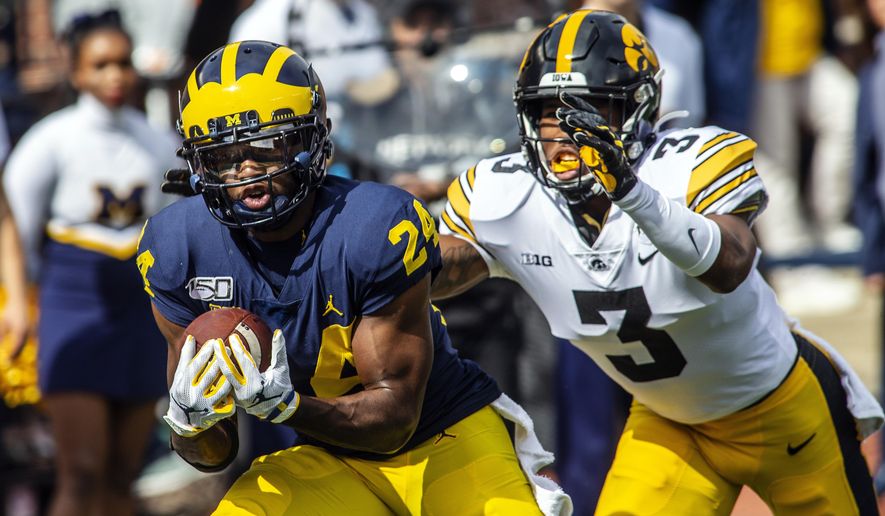 Michigan defensive back Lavert Hill (24) intercepts a pass intended for Iowa wide receiver Tyrone Tracy, Jr. (3) in the second quarter of an NCAA college football game in Ann Arbor, Mich., Saturday, Oct. 5, 2019. (AP Photo/Tony Ding)