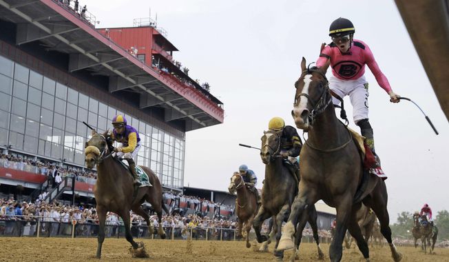 In this May 18, 2019, file photo, jockey Tyler Gaffalione, right, reacts aboard War of Will, as they cross the finish line first to win the Preakness Stakes horse race at Pimlico Race Course in Baltimore. The owners of the historic racetrack that hosts the Preakness Stakes and Baltimore officials have reached an agreement to keep the Triple Crown series&#x27; middle jewel in the city. (AP Photo/Steve Helber, File)