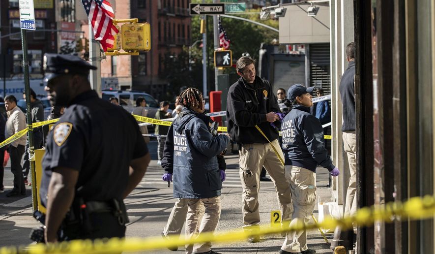 New York Police Department officers investigate the scene of an attack in Manhattan's Chinatown neighborhood, Saturday, Oct. 5, 2019 in New York. Four men who are believed to be homeless were attacked and killed early Saturday in a street rampage. NYPD Detective Annette Shelton said that a fifth man remained in critical condition after also being struck with a long metal object that authorities recovered. (AP Photo/Jeenah Moon)