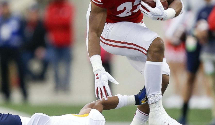 Wisconsin running back Jonathan Taylor runs past Kent State safety Elvis Hines during the first half of an NCAA college football game Saturday, Oct. 5, 2019, in Madison, Wis. (AP Photo/Andy Manis)