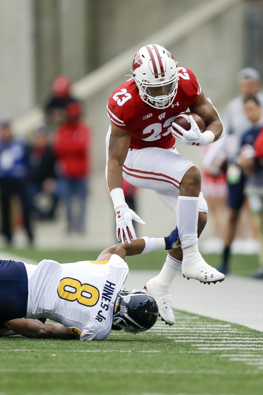 Wisconsin running back Jonathan Taylor runs past Kent State safety Elvis Hines during the first half of an NCAA college football game Saturday, Oct. 5, 2019, in Madison, Wis. (AP Photo/Andy Manis)