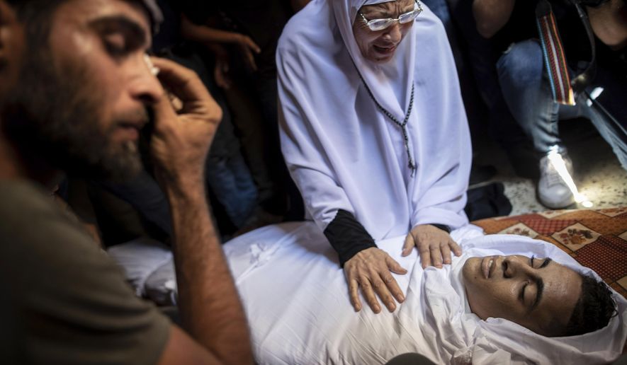 Relatives of Saher Othman, 20, mourn over his body in the family home during his funeral in Rafah refugee camp, southern Gaza Strip, Saturday, Sept. 28, 2019. Gaza's Health Ministry says Othman has been killed by Israeli gunfire during protests along Gaza-Israel border. (AP Photo/Khalil Hamra)