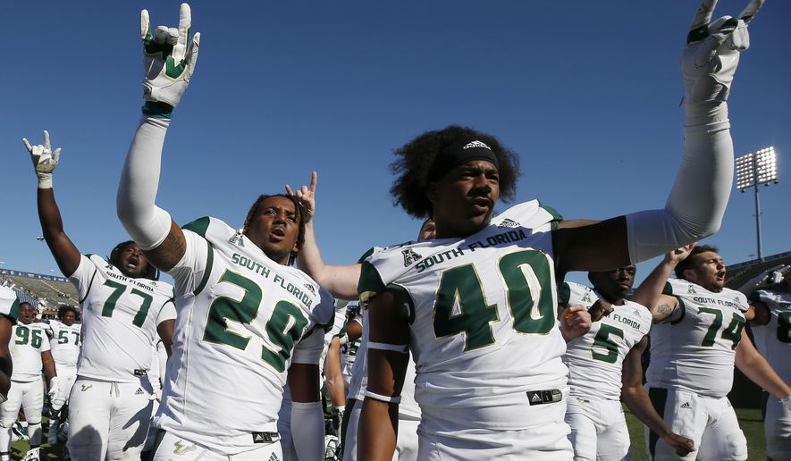 South Florida linebacker Brian Norris (29) and defensive end Jason Vaughn (40) celebrate with teammates after defeating Connecticut in an NCAA college football game in East Hartford, Conn., Saturday, Oct. 5, 2019. (AP Photo/Michael Dwyer)