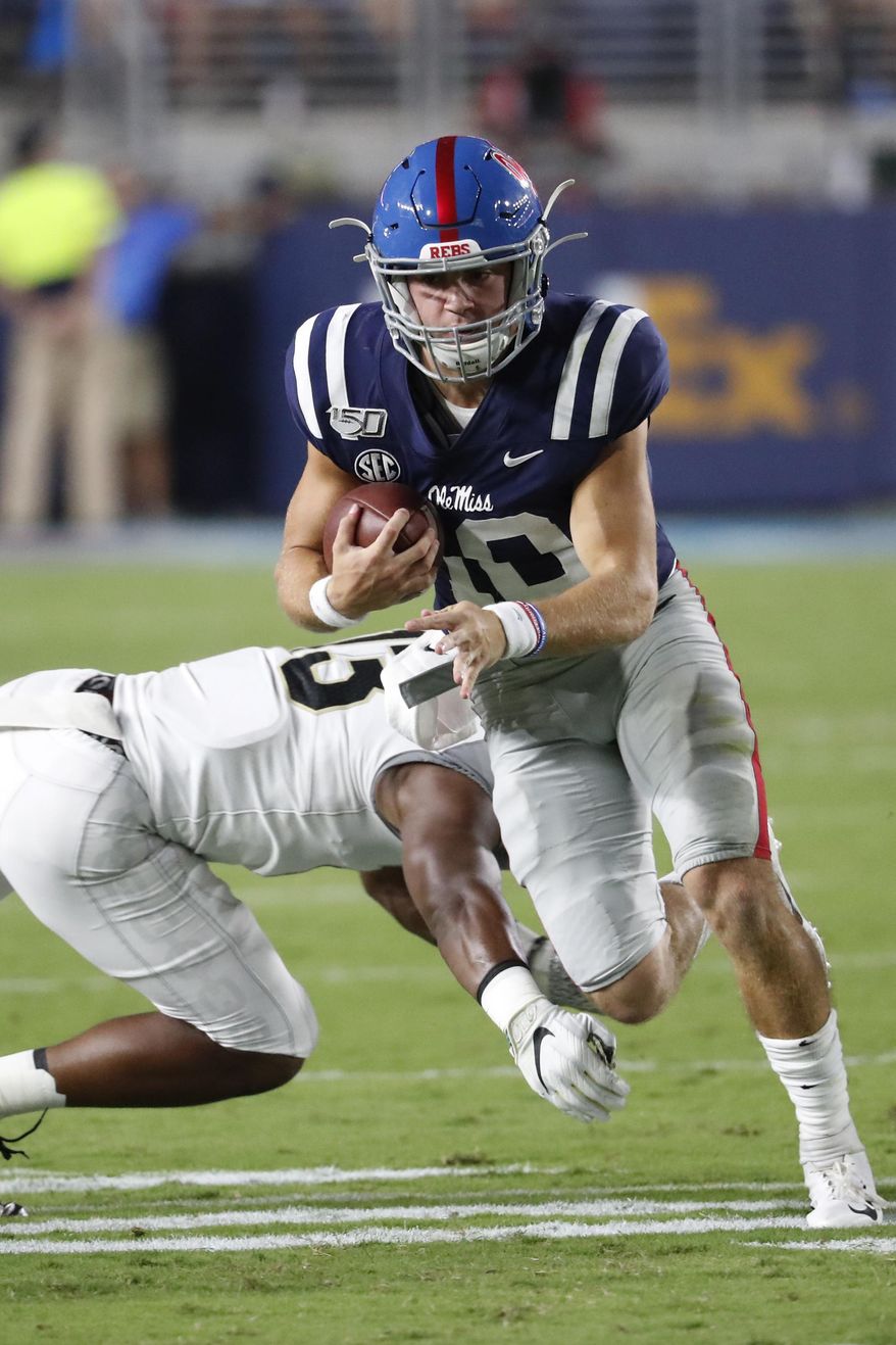 Mississippi quarterback John Rhys Plumlee (10) evades a Vanderbilt tackle as he runs for a first down during the first half of an NCAA college football game in Oxford, Miss., Saturday, Oct. 5, 2019. (AP Photo/Rogelio V. Solis)