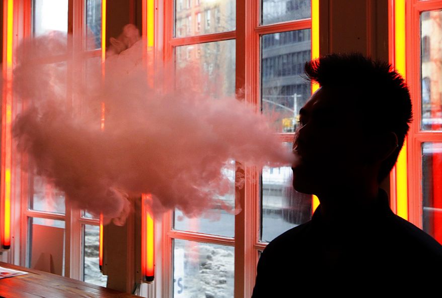 In this Feb. 20, 2014, file photo, a patron exhales vapor from an e-cigarette at a store in New York. (AP Photo/Frank Franklin II, File)