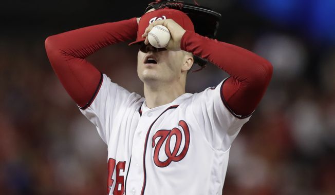 Washington Nationals starting pitcher Patrick Corbin covers his face after allowing a two-run double to Los Angeles Dodgers Russell Martin during the sixth inning in Game 3 of a baseball National League Division Series on Sunday, Oct. 6, 2019, in Washington. (AP Photo/Julio Cortez)