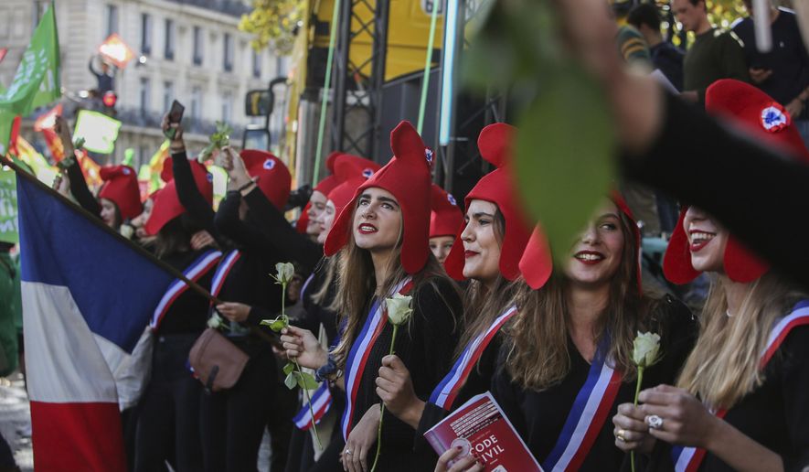 Conservative activists gather to protest in Paris, Sunday Oct. 6, 2019, against a French bill that would give lesbian couples and single women access to in vitro fertilization and related procedures. Traditional Catholic groups and far-right activists organized Sunday's protest, arguing that it deprives children of the right to a father. (AP Photo/Rafael Yaghobzadeh)