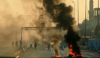 Iraqi security forces fire tear gas to disperse anti-government protesters who set fires and close a street during a demonstration in Baghdad, Iraq, Saturday, Oct. 5, 2019. The spontaneous protests which started Tuesday in Baghdad and southern cities were sparked by endemic corruption and lack of jobs. Security forces responded with a harsh crackdown, with dozens killed. (AP Photo/Hadi Mizban)