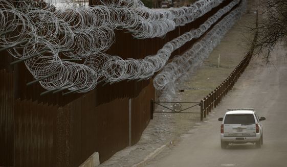 In this March 2, 2019 file photo a Customs and Border Control agent patrols on the US side of a razor-wire-covered border wall that separates Nogales, Mexico from Nogales, Ariz. A U.S. Border Patrol agent has died after being found unresponsive while on patrol near the Arizona border, but authorities say there&#39;s no evidence of foul play. The agency&#39;s Tucson sector says in a Monday, Oct. 7, 2019, statement that agents on Sunday found 44-year-old Robert Hotten unresponsive near Mount Washington south of Patagonia in southeastern Arizona. He was patrolling alone, which is customary. (AP Photo/Charlie Riedel,File)