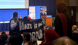 Acting Homeland Security Secretary Kevin McAleenan takes the podium at a immigration law and policy conference, Monday, Oct. 7, 2019 in Washington.  As he took the stage, a handful of protesters stood up and held large black banners, one read Hate is Not Normal, and shouted out that children were under attack. They also began yelling the names of children who had died after they were in immigration custody. McAleenan was scheduled as the keynote speaker at Georgetown University Law Center during an annual immigration law and policy conference held by the nonprofit immigration think tank Migration Policy Institute.  (AP Photo/Colleen Long