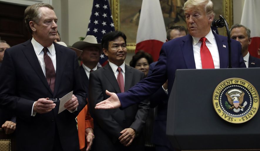 President Donald Trump gestures to  U.S. Trade Representative Robert Lighthizer, left, before signing a trade agreement with Japan in the Roosevelt Room of the White House, Monday, Oct. 7, 2019, in Washington. (AP Photo/Evan Vucci)