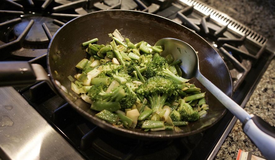 FILE - This Aug. 5, 2006 file photo shows a vegetable stir fry dish being prepared in New York. Stir-fry technique has many people intimidated. But if you can slice and stir, you can stir fry. (AP Photo/Richard Drew, File)