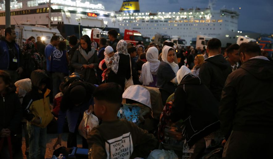 Migrants and refugees arrive from Lesbos island to the port of Piraeus, near Athens, Monday Oct. 7, 2019. In the last 24 hours 668 refugees and migrants have been transferred to mainland Greece from five Greek islands as authorities have accelerated efforts to ease over crowding in the camps. (AP Photo/Thanassis Stavrakis)