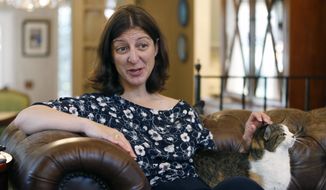 Rep. Elaine Luria, D-Va., pets her cat, Bijous, during an interview in her home in Norfolk, Va., Thursday, Oct. 3, 2019. Luria recently joined a group of other Congresswomen to call for the impeachment of President Trump. (AP Photo/Steve Helber)