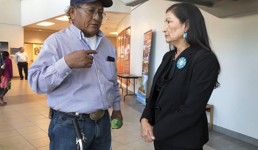 Leslie Begay, left, speaks with U.S. Rep. Deb Haaland, D-New Mexico, in a hallway outside a congressional field hearing in Albuquerque, N.M., highlighting the atomic age's impact on Native American communities on Monday, Oct. 7, 2019. Begay, a former uranium miner on the Navajo Nation with lung problems, says there are lingering injustices and health problems on his reservation decades after mines closed. An Indian Health Service official cited federal research at the hearing that she says showed some Navajo women, males and babies who were part of the study had high levels of uranium in their systems. (AP Photo/Mary Hudetz)