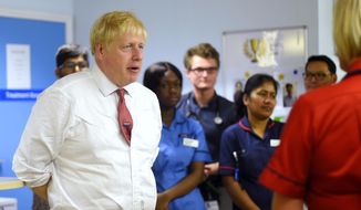 Britain&#39;s Prime Minister Boris Johnson speaks to mental health professionals during his visit to Watford General Hospital, in Watford, Monday, Oct. 7, 2019. Britain and the European Union appeared to be poles apart Monday on a potential Brexit deal, with the Dutch government urging the British government to offer &amp;quot;more realism and clarity,&amp;quot; and U.K. Prime Minister Boris Johnson insisting the bloc has to soften its stance. (Peter Summers/Pool Photo via AP)
