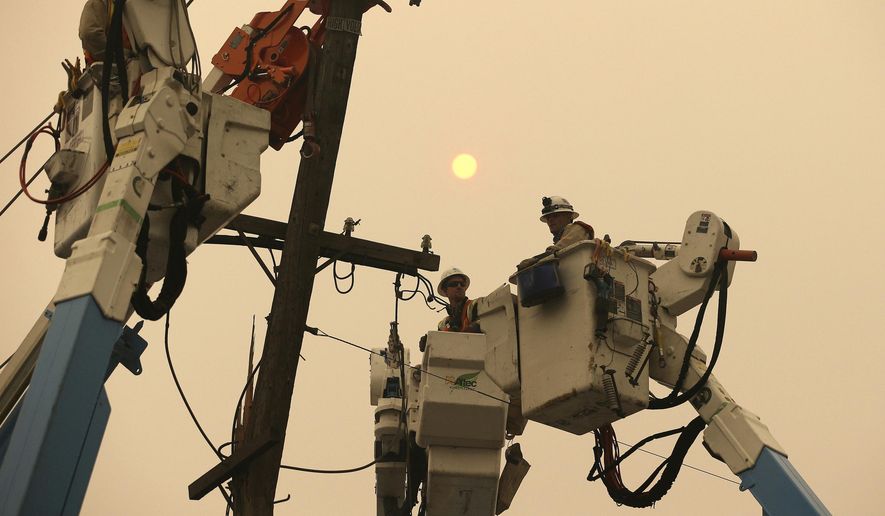 FILE - In this Nov. 9, 2018, file photo, Pacific Gas & Electric crews work to restore power lines in Paradise, Calif. Two years to the day after some of the deadliest wildfires tore through Northern California wine country, two of the state's largest utilities were poised Tuesday, Oct. 8, 2019, to shut off power to more than 700,000 customers in 37 counties, in what would be the largest preventive shut-off to date as utilities try to head off wildfires caused by faulty power lines. (AP Photo/Rich Pedroncelli, File)