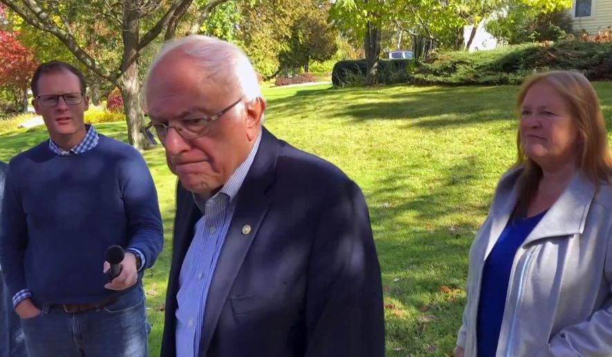 In this image taken from video, Democratic presidential candidate Sen. Bernie Sanders, I-Vt., speaks we reporters outside his home, Tuesday, Oct. 8, 2019, in Burlington, Vt. His wife, Jane O'Meara Sanders listens at right. Sanders says he was "dumb" not to have listened to the symptoms he was experiencing before he was stricken with a heart attack last week. (AP Photo/Wilson Ring)
