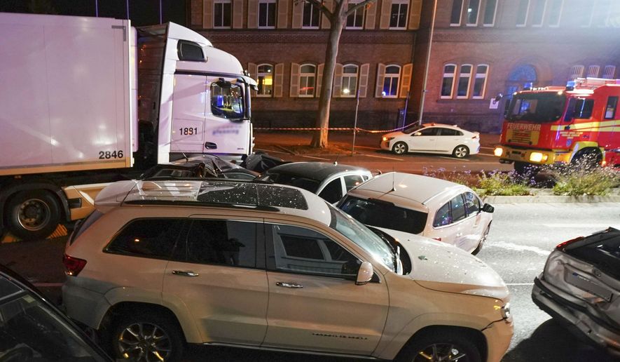 In this Monday, Oct. 7, 2019 photo s truck stands between damaged cars in Limburg, Germany. The truck drove into a line of eight cars in Limburg late Monday afternoon, pushing the vehicles into each other. Police said seven people were taken to hospitals and the driver also was slightly injured. He was detained. (Thorsten Wagner/dpa via AP)