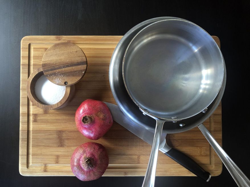 This Oct. 2, 2019 photo shows kosher salt, a couple of pans, a chefs knife and two pomegranates on a cutting board displayed in New York. From avoiding unsalting to making sure you're not working with a dull knife, there are certain mistakes that are pretty easy to avoid in the kitchen, once you know what to look out for. Others include not fiddling with the food while it cooks and not forgetting about carryover cooking. (Katie Workman via AP)