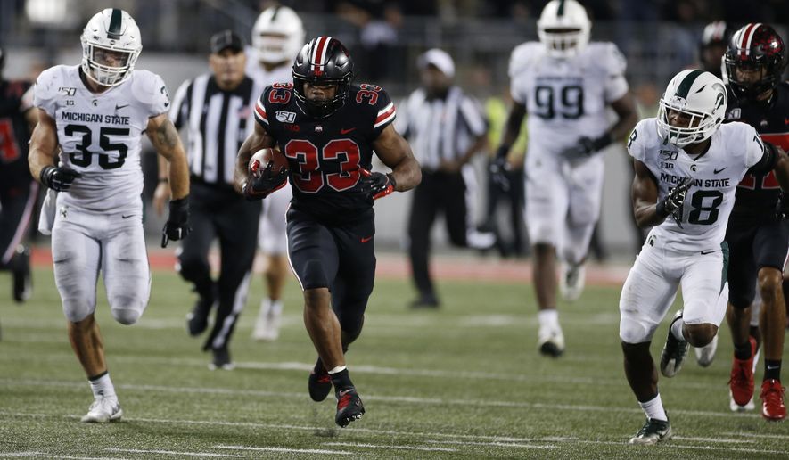 Ohio State running back Master Teague, center, breaks through the line of scrimmage against Michigan State during the second half of an NCAA college football game Saturday, Oct. 5, 2019, in Columbus, Ohio. Ohio State won 34-10. (AP Photo/Jay LaPrete)