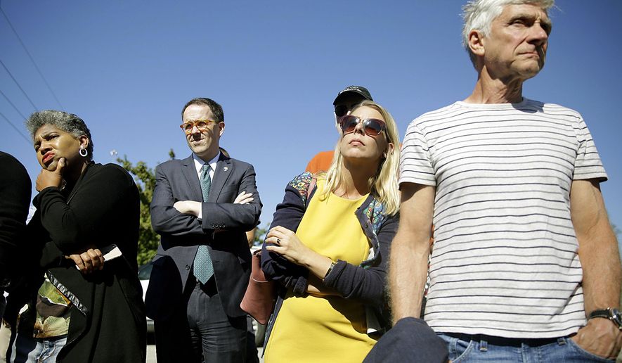 In this Monday, Oct. 7, 2019 photo, Rep. Regina Goodwin, left, Mayor G.T. Bynum, second from left, and others listen to researchers talk about their search for possible mass burial graves from Tulsa's 1921 Race Massacre at Oaklawn Cemetery in Tulsa, Okla. (Mike Simons/Tulsa World/Tulsa World via AP)