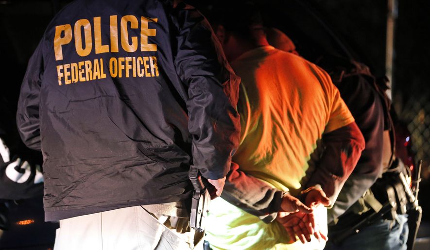 In this Oct. 22, 2018, photo U.S. Immigration and Customs Enforcement agents surround and detain a person during a raid in Richmond, Va. ICE's enforcement and removal operations, like the five-person field office team outside Richmond, hunt people in the U.S. illegally, some of whom have been here for decades, working and raising families. Carrying out President Donald Trump's hard-line immigration policies has exposed ICE to unprecedented public scrutiny and criticism, even though officers say they're doing largely the same job they did before the election, prioritizing criminals. (AP Photo/Steve Helber)