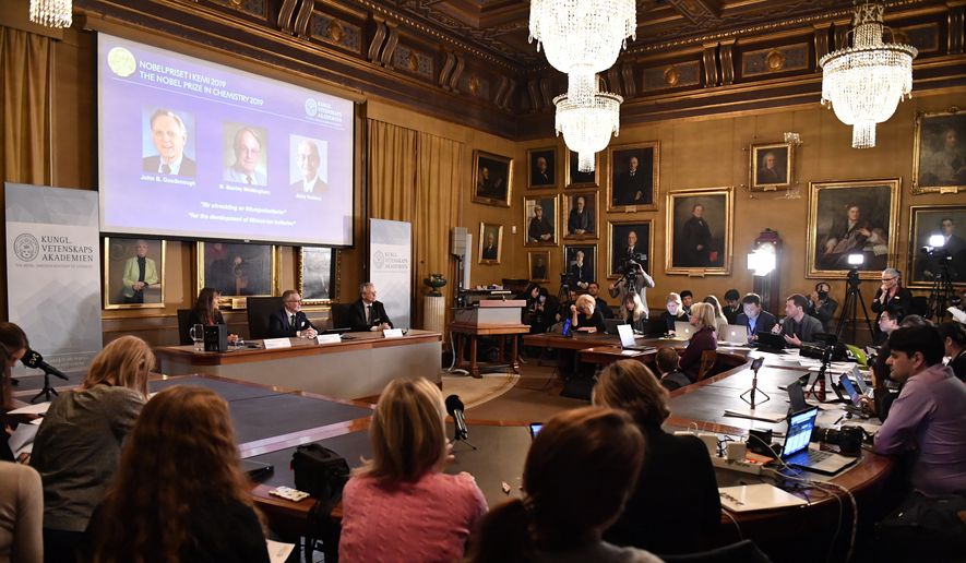 Goran K Hansson, center, Secretary General of the Royal Swedish Academy of Sciences, and academy members Sara Snogerup Linse, left, and Olof Ramstrom announce the winners of the 2019 Nobel Prize in Chemistry, shown on the screen, from left, John B. Goodenough, M. Stanley Whittingham, and Akira Yoshino "for the development of lithium-ion batteries," during a news conference at the Royal Swedish Academy of Sciences in Stockholm, Sweden, Wednesday Oct. 9, 2019. (Naina Helen Jama/TT via AP)