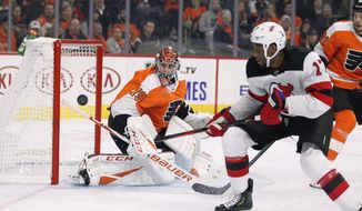 New Jersey Devils&#39; Wayne Simmonds, right, chases the puck as Philadelphia Flyers&#39; Carter Hartnwatches during the first period of an NHL hockey game Wednesday, Oct. 9, 2019, in Philadelphia. (AP Photo/Tom Mihalek)