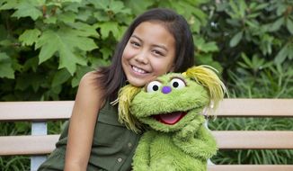 This undated image released by Sesame Workshop shows 10-year-old Salia Woodbury, whose parents are in recovery, with &amp;quot;Sesame Street&amp;quot; character Karli. Sesame Workshop is addressing the issue of addiction. Data shows 5.7 million children under 11 live in households with a parent with substance use disorder. Karli had already been introduced as a puppet in foster care earlier this year but viewers now will understand why her mother had to go away for a while. (Flynn Larsen/Sesame Workshop via AP)
