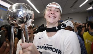 Washington Mystics center Emma Meesseman holds the trophy in the locker room after Game 5 of basketball&#39;s WNBA Finals against the Connecticut Sun, Thursday, Oct. 10, 2019 in Washington. (AP Photo/Alex Brandon) ** FILE **