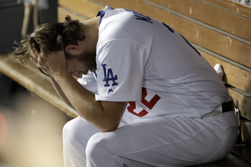 Los Angeles Dodgers pitcher Clayton Kershaw sits in the dugout after giving up back-to-back home runs to the Washington Nationals during the eighth inning in Game 5 of a baseball National League Division Series on Wednesday, Oct. 9, 2019, in Los Angeles. (AP Photo/Marcio Jose Sanchez)