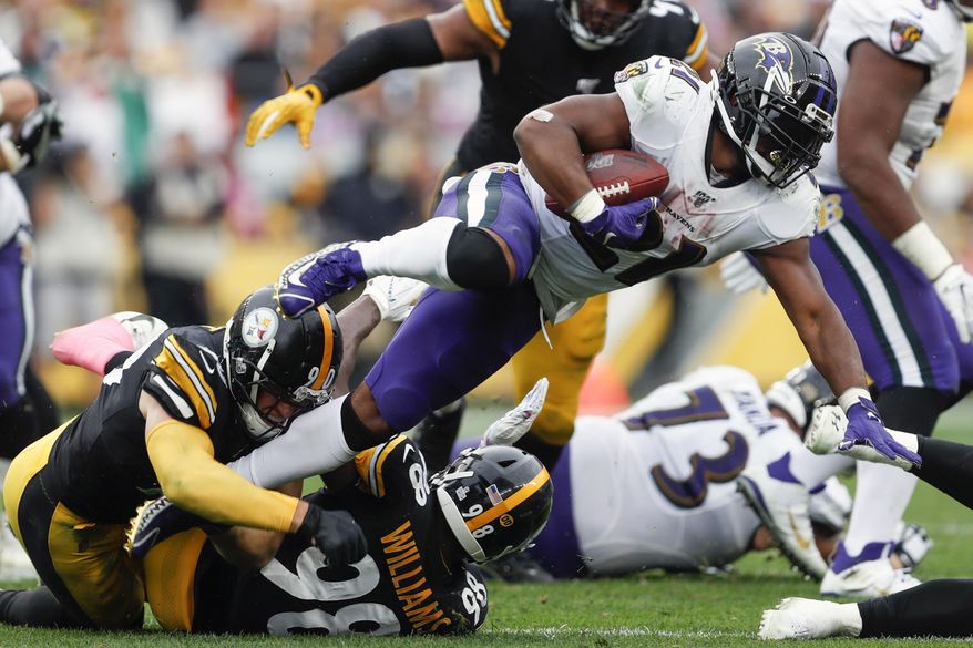 Baltimore Ravens running back Mark Ingram (21) leaps over Pittsburgh Steelers outside linebacker T.J. Watt (90) on a run in the second half of an NFL football game, Sunday, Oct. 6, 2019, in Pittsburgh. (AP Photo/Don Wright)
