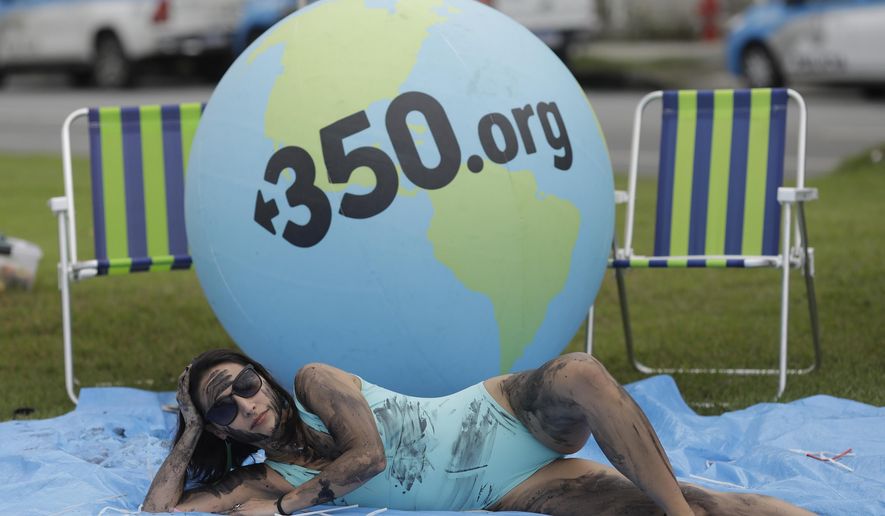 A demonstrator painted with fake oil lies on a tarp during a protest against the auction for the exploration of oil fields close to Abrolhos, a marine national park in Bahia state, in front of the Grand Hyatt Hotel where the auction is taking place, in Rio de Janeiro, Brazil, Thursday, Oct. 10, 2019. Under pressure from environmental organizations, none of the 17 companies involved in the process presented any offers. (AP Photo/Silvia Izquierdo)