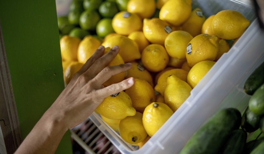 In this Aug. 21, 2019, photo a worker stocks a produce stand at a metro station in Atlanta. On Thursday, Oct. 10, the Labor Department reports on U.S. consumer prices for September. (AP Photo/David Goldman)
