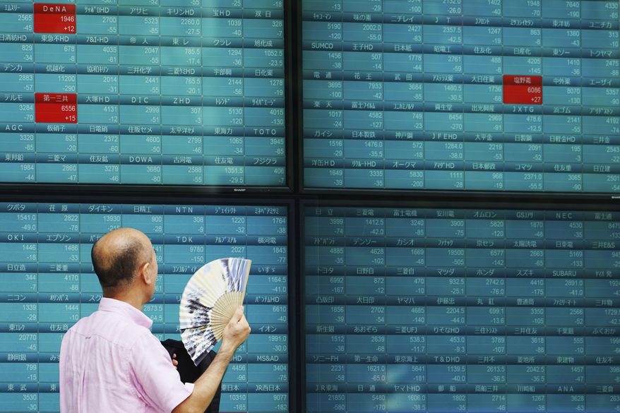 In this Thursday, Oct. 3, 2019, photo, a man looks at an electronic stock board showing Japan&#x27;s Nikkei 225 index at a securities firm in Tokyo. Asian shares were mixed Thursday, Oct. 10, following broad gains on Wall Street as investors pondered mixed reports on the likelihood of progress in resolving the trade war between the U.S. and China. (AP Photo/Eugene Hoshiko)