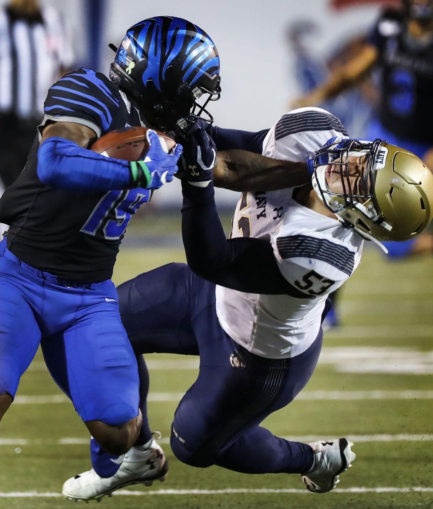 Memphis running back Kenneth Gainwell, left, stiff-arms Navy defender Tama Tuitele during an NCAA college football game Thursday, Sept. 26, 2019, in Memphis, Tenn. (Mark Weber/Daily Memphian via AP)