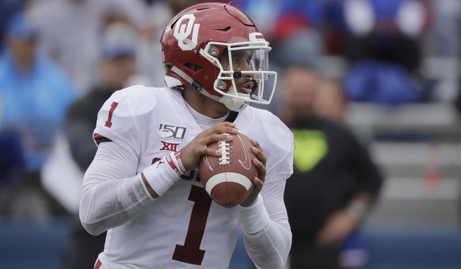 Oklahoma quarterback Jalen Hurts looks for a receiver during the second half of an NCAA college football game against Kansas, Saturday, Oct. 5, 2019, in Lawrence, Kan. (AP Photo/Charlie Riedel)