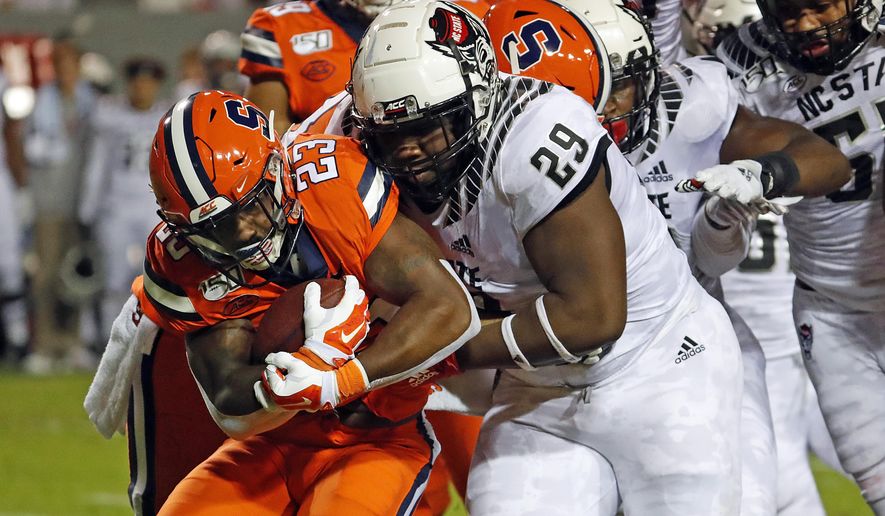 North Carolina State's Alim McNeill (29) ties up Syracuse's Abdul Adams (23) during the first half of an NCAA college football game in Raleigh, N.C., Thursday, Oct. 10, 2019. (AP Photo/Karl B DeBlaker)
